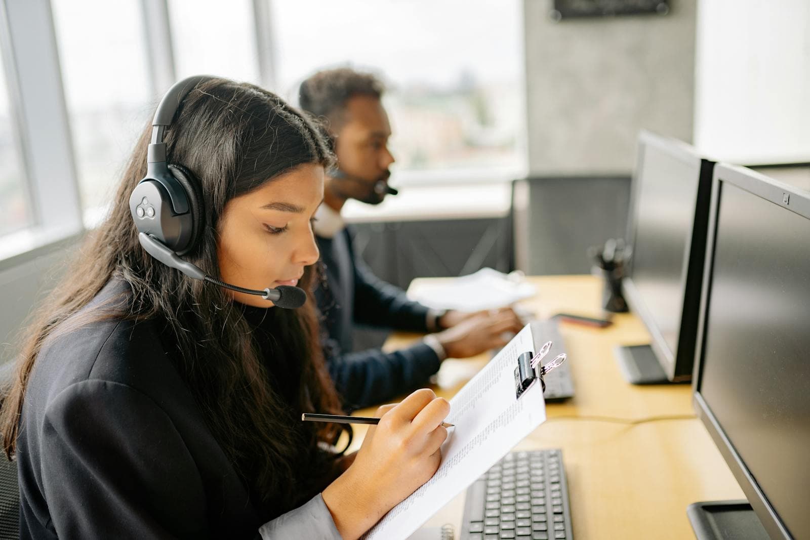 Quality analyst reviewing recorded calls with headphones