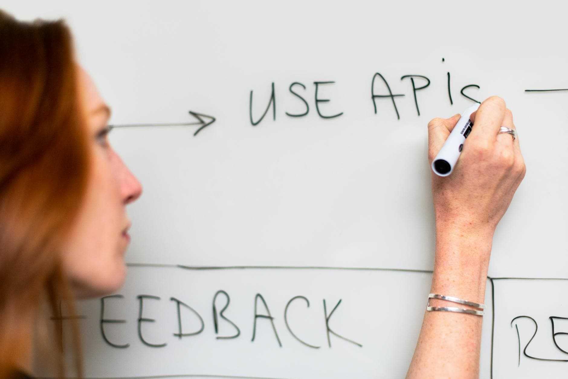 Developer planning API integration architecture on a whiteboard, illustrating claims payment system design