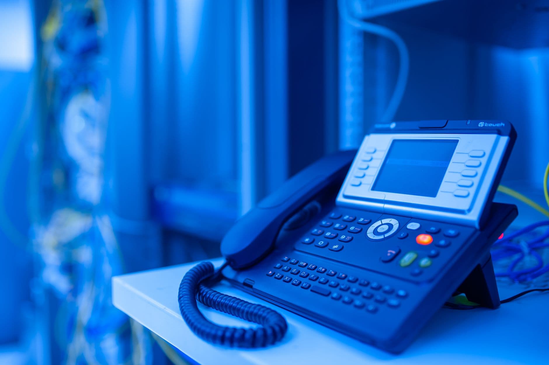 Phone keypad with finger pressing button — illustrating DTMF entry inside a TCPA compliant payment IVR