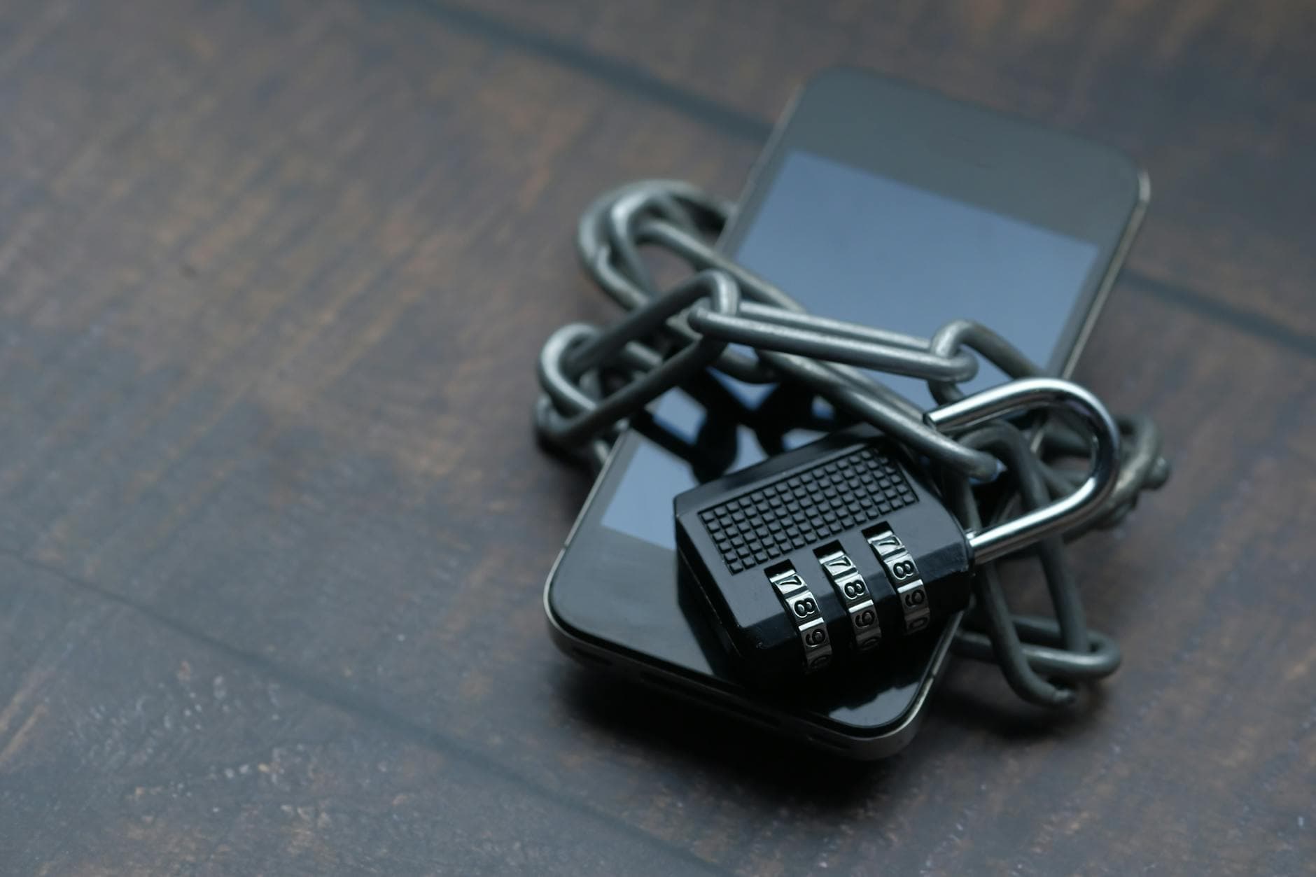 Smartphone wrapped in a chain with a padlock — payment security