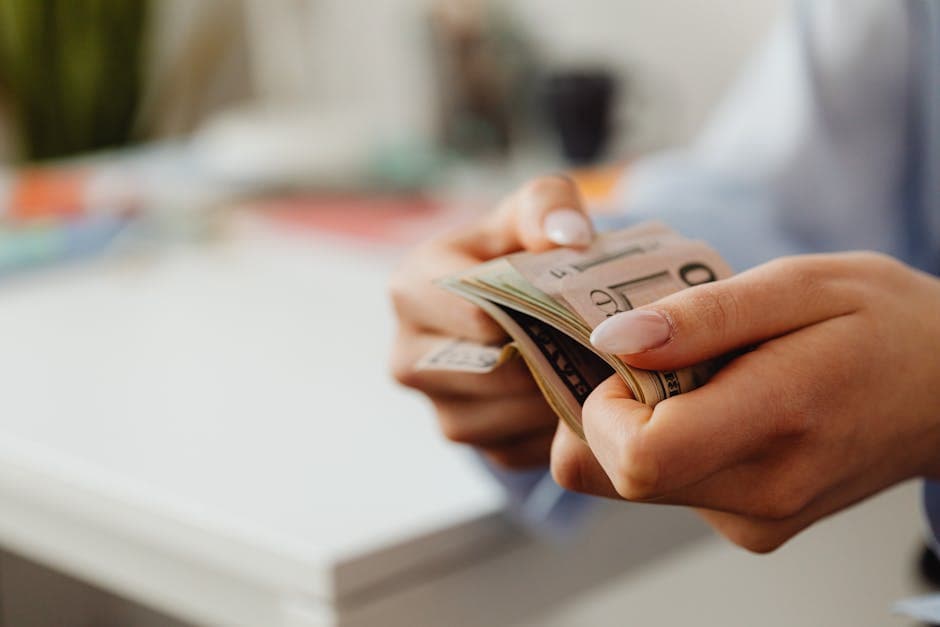 Hand holding a check next to a laptop representing ACH bank transfer authorization