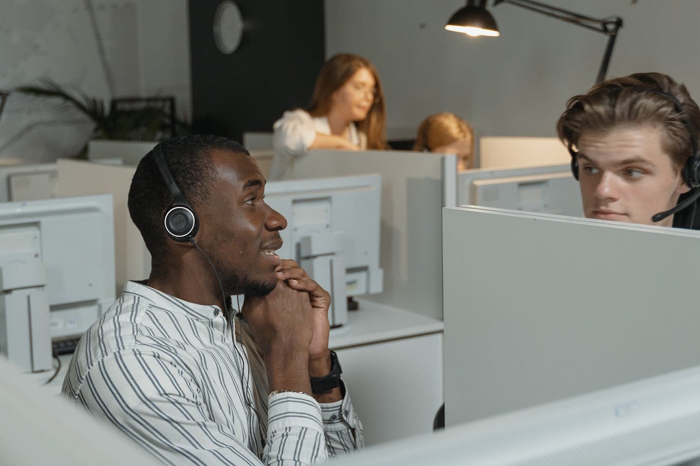 Insurance contact-centre team collaborating in headsets while handling customer calls and payments
