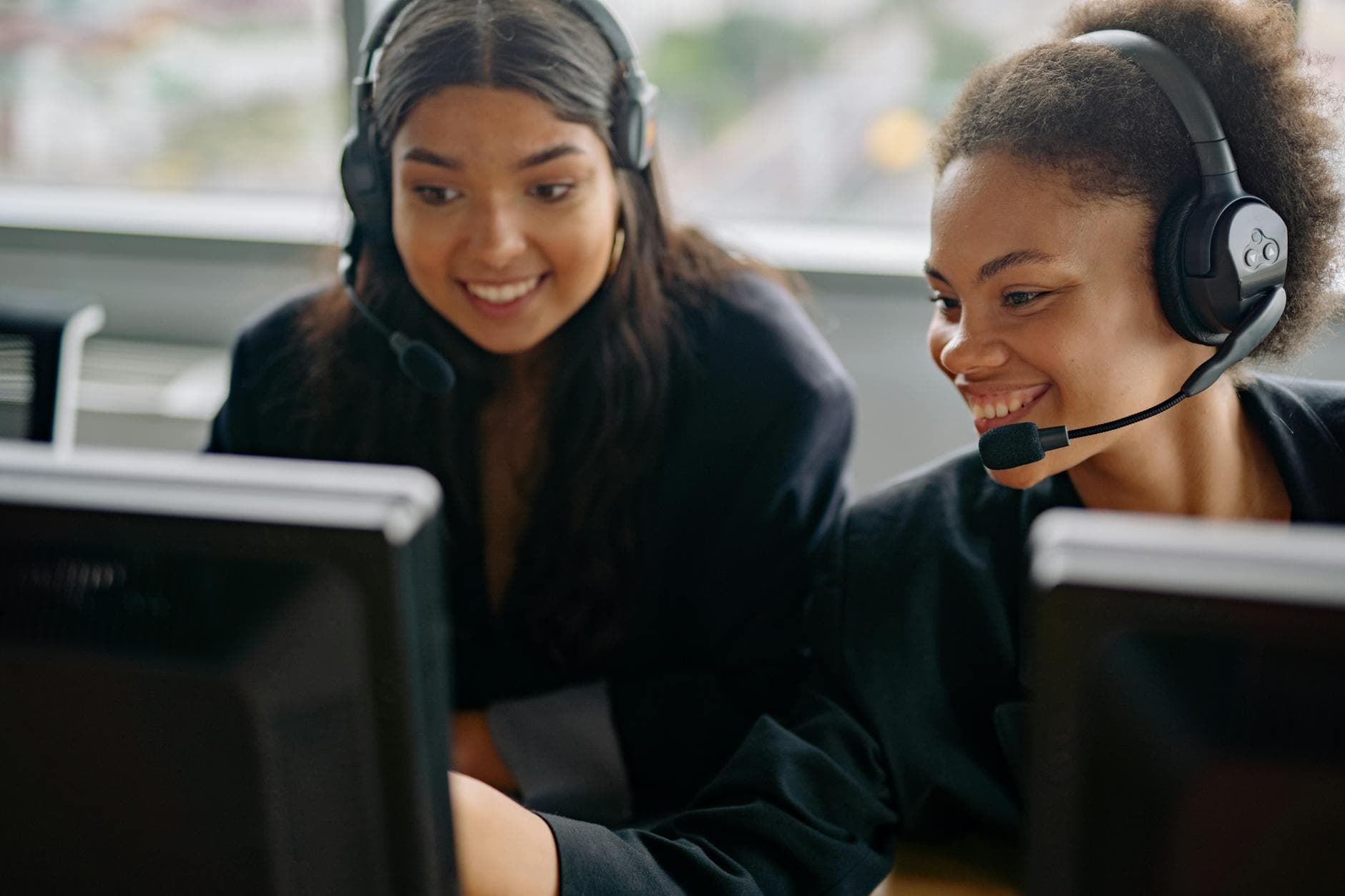 Two cheerful call center agents at work, engaging with customers and providing support.