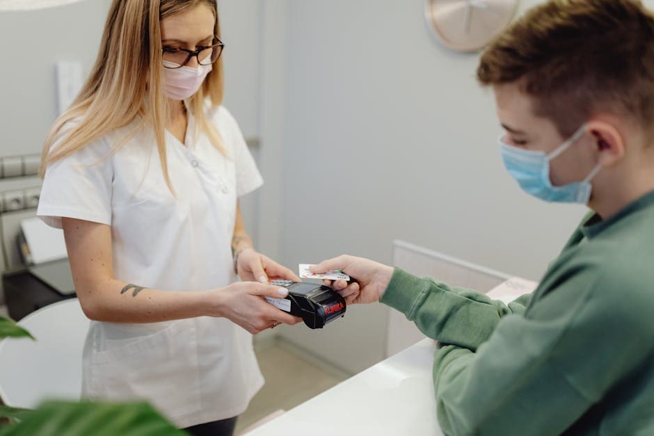 US medical billing clerk processing a patient payment at a hospital front desk