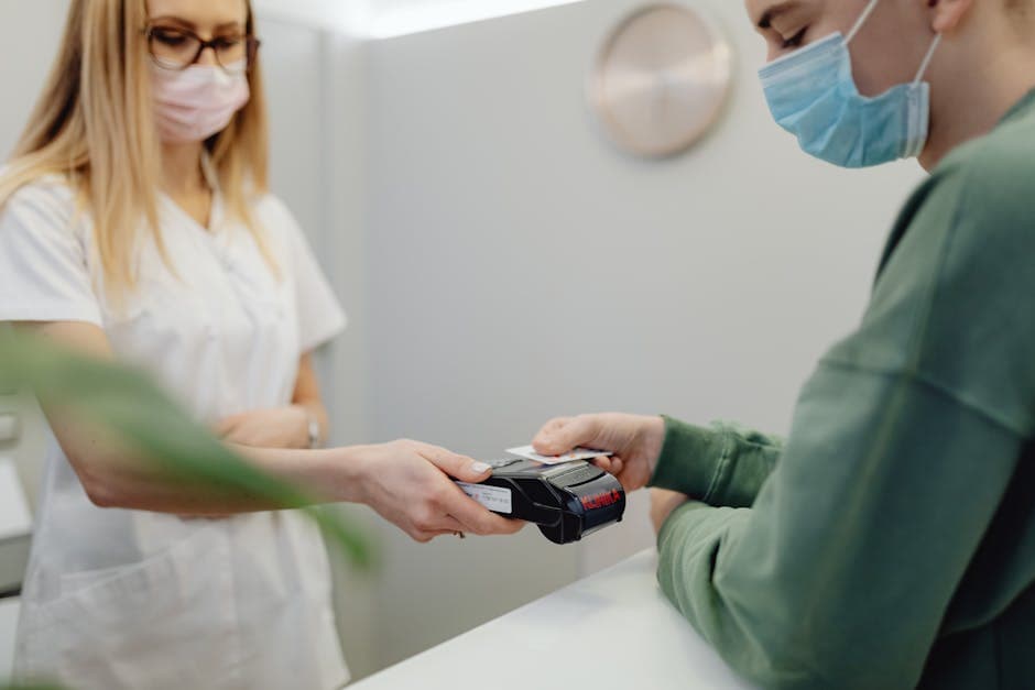 US doctor's office reception desk with a patient paying a bill by card