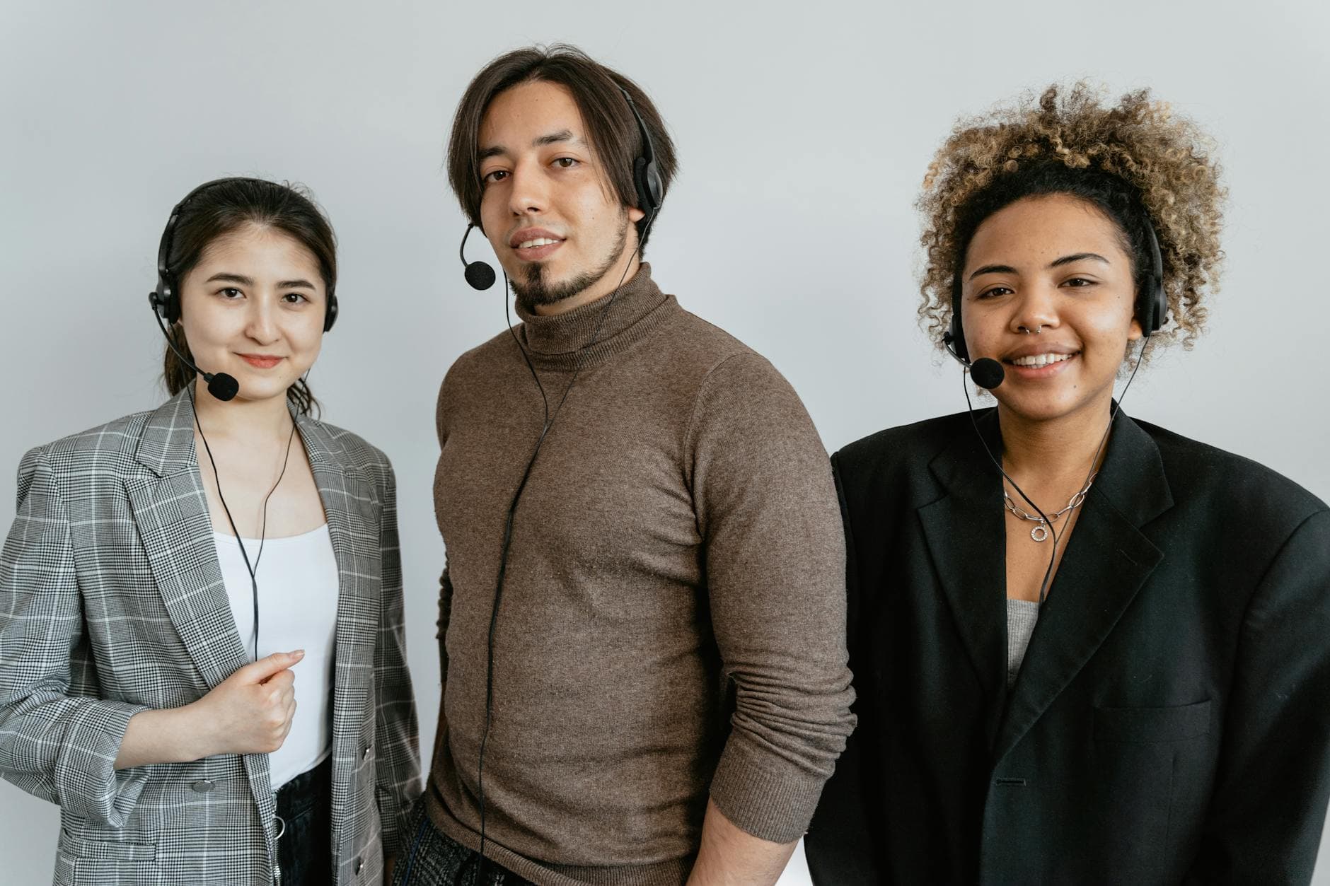 Three diverse call center employees wearing headsets, ready to assist customers.