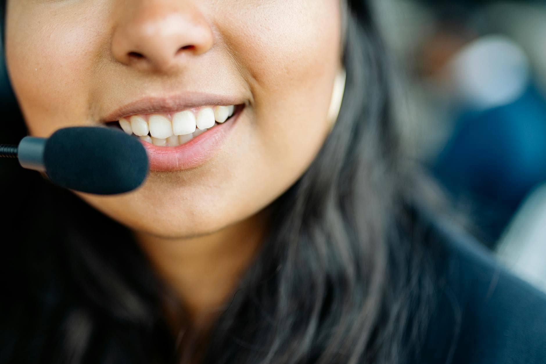 Smiling customer service agent wearing a headset in a modern US office, ready to take a call