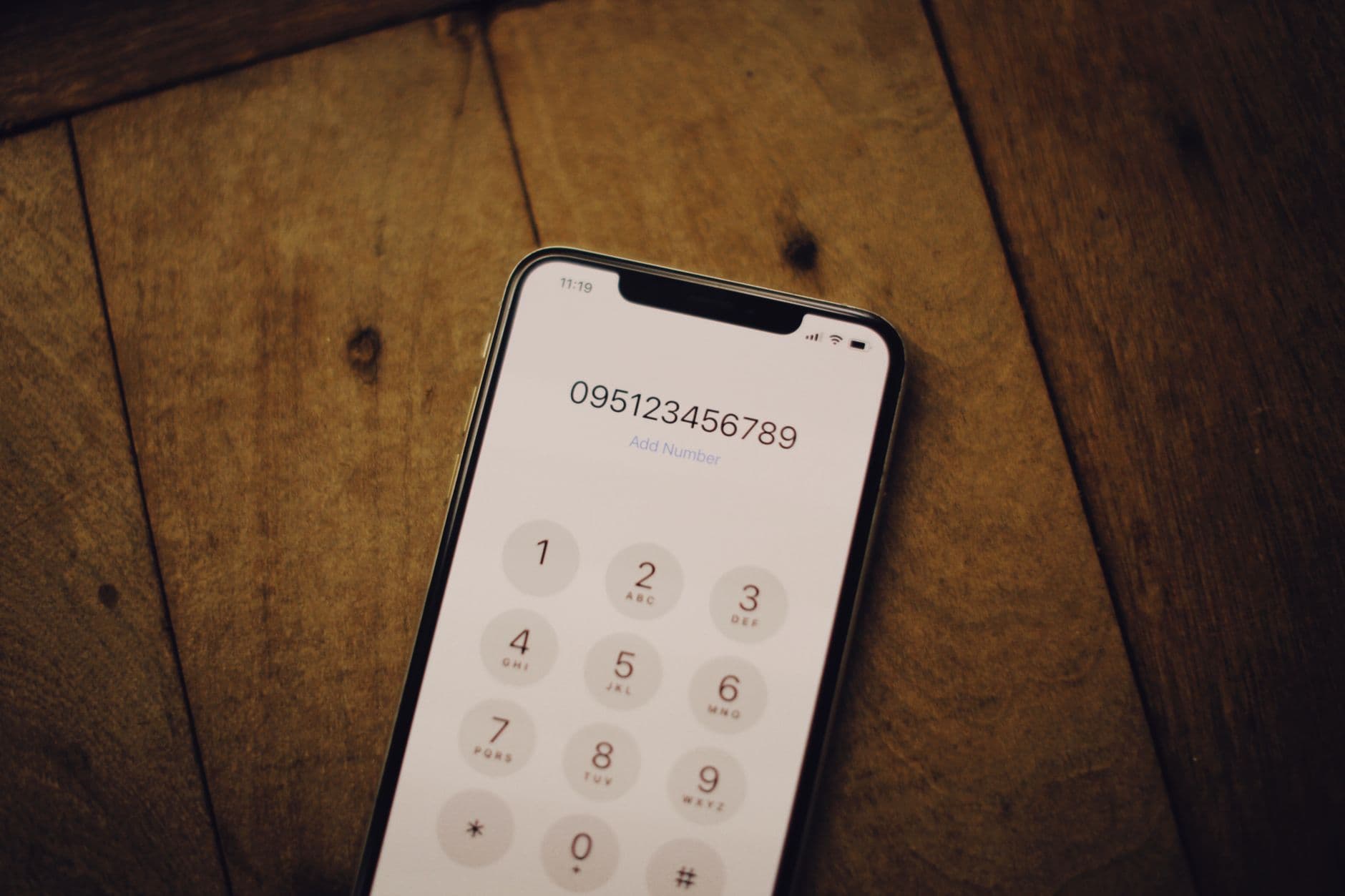 Close-up of a smartphone showing a numeric dial pad, used to enter payment details over the phone