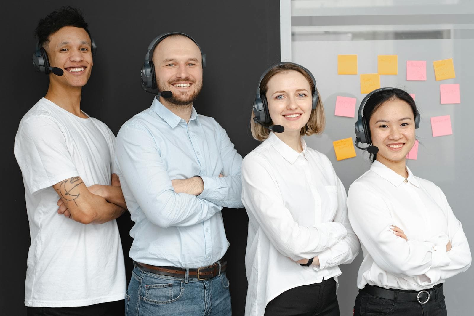Diverse contact centre team in a modern office wearing headsets, standing confidently together