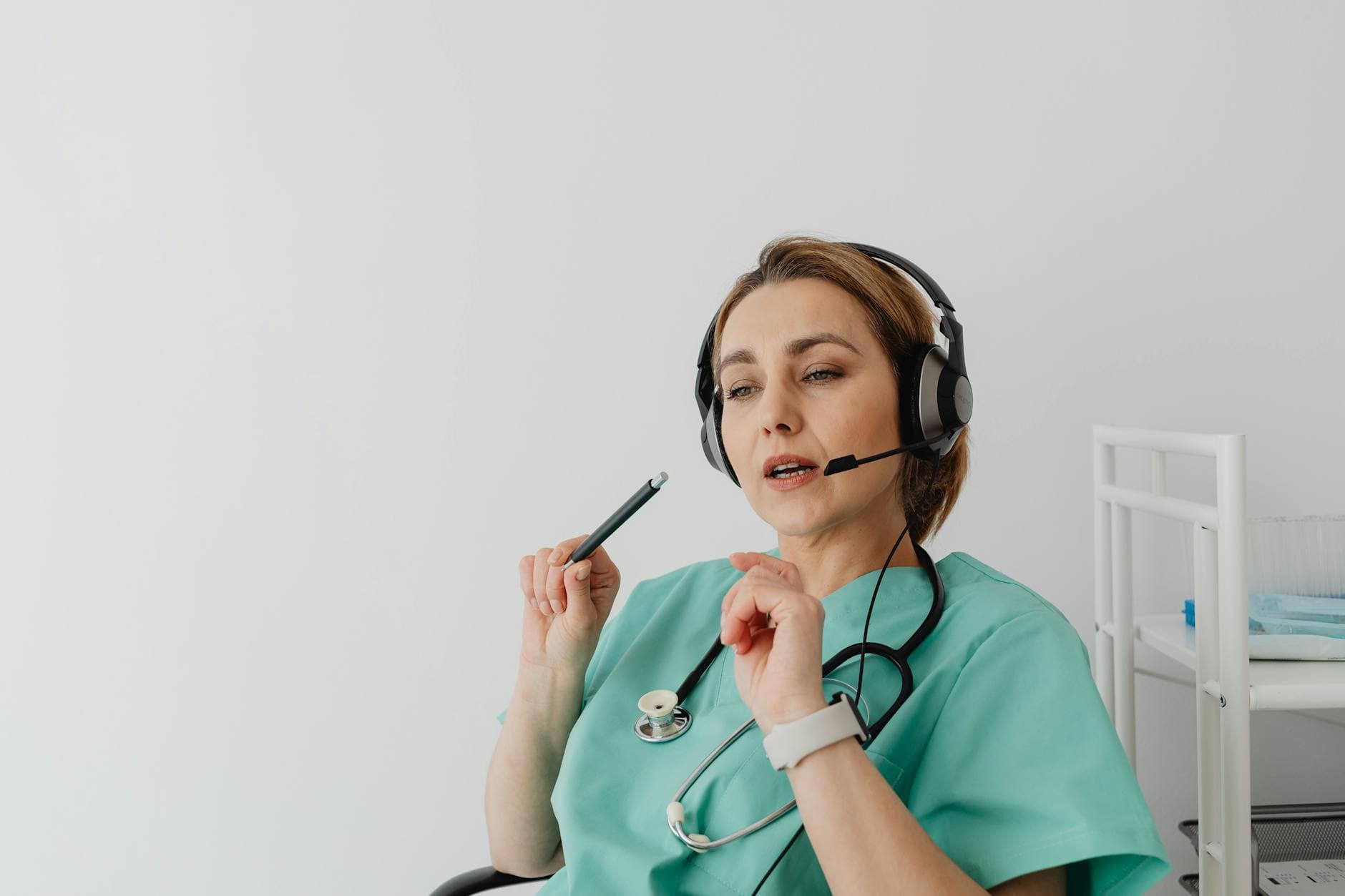 Healthcare professional wearing headset takes a phone payment from a patient