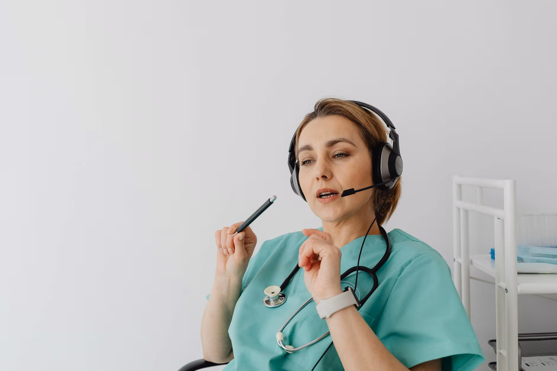 Healthcare professional wearing headset takes a phone payment from a patient