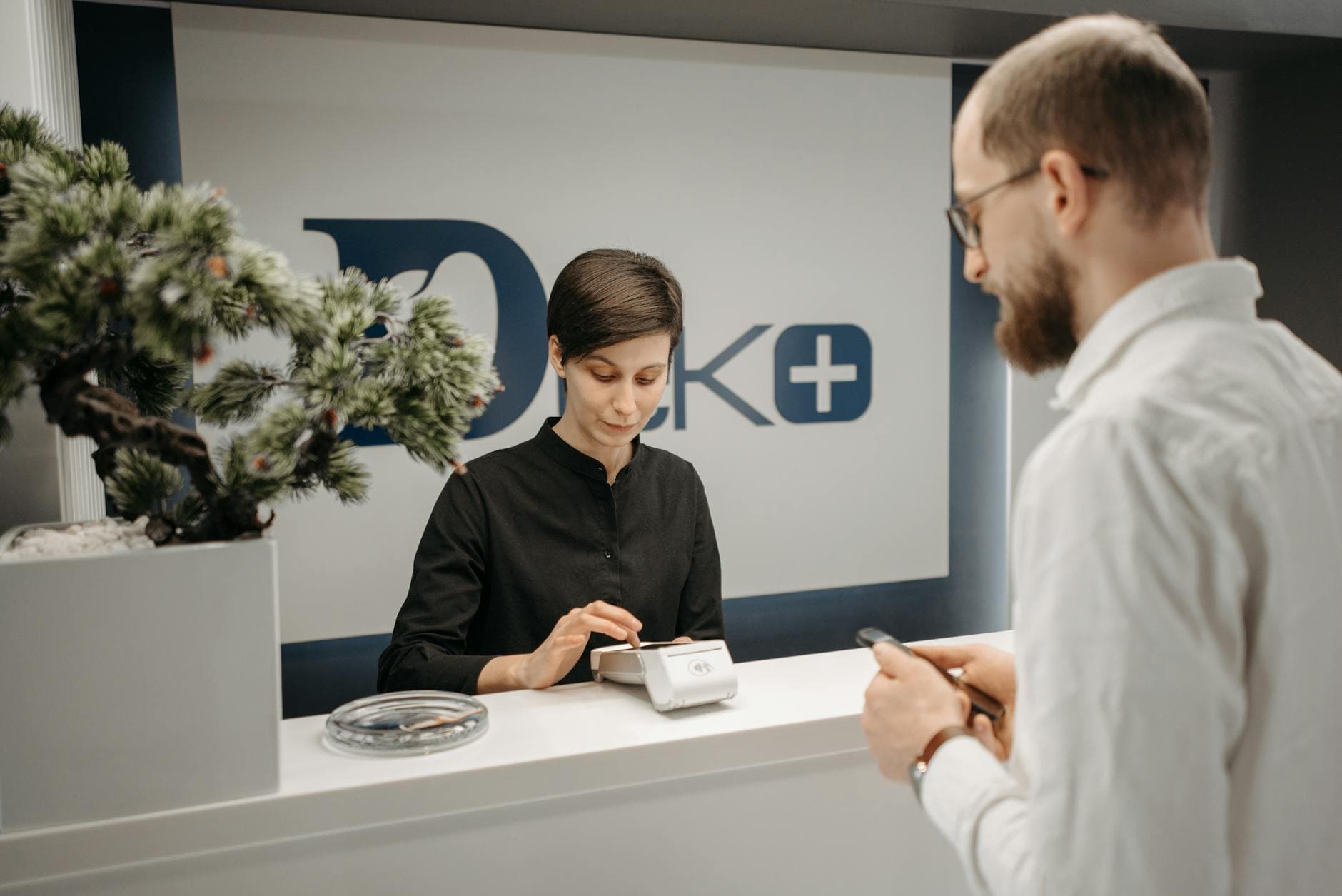 Patient making a cashless card payment at a medical clinic reception