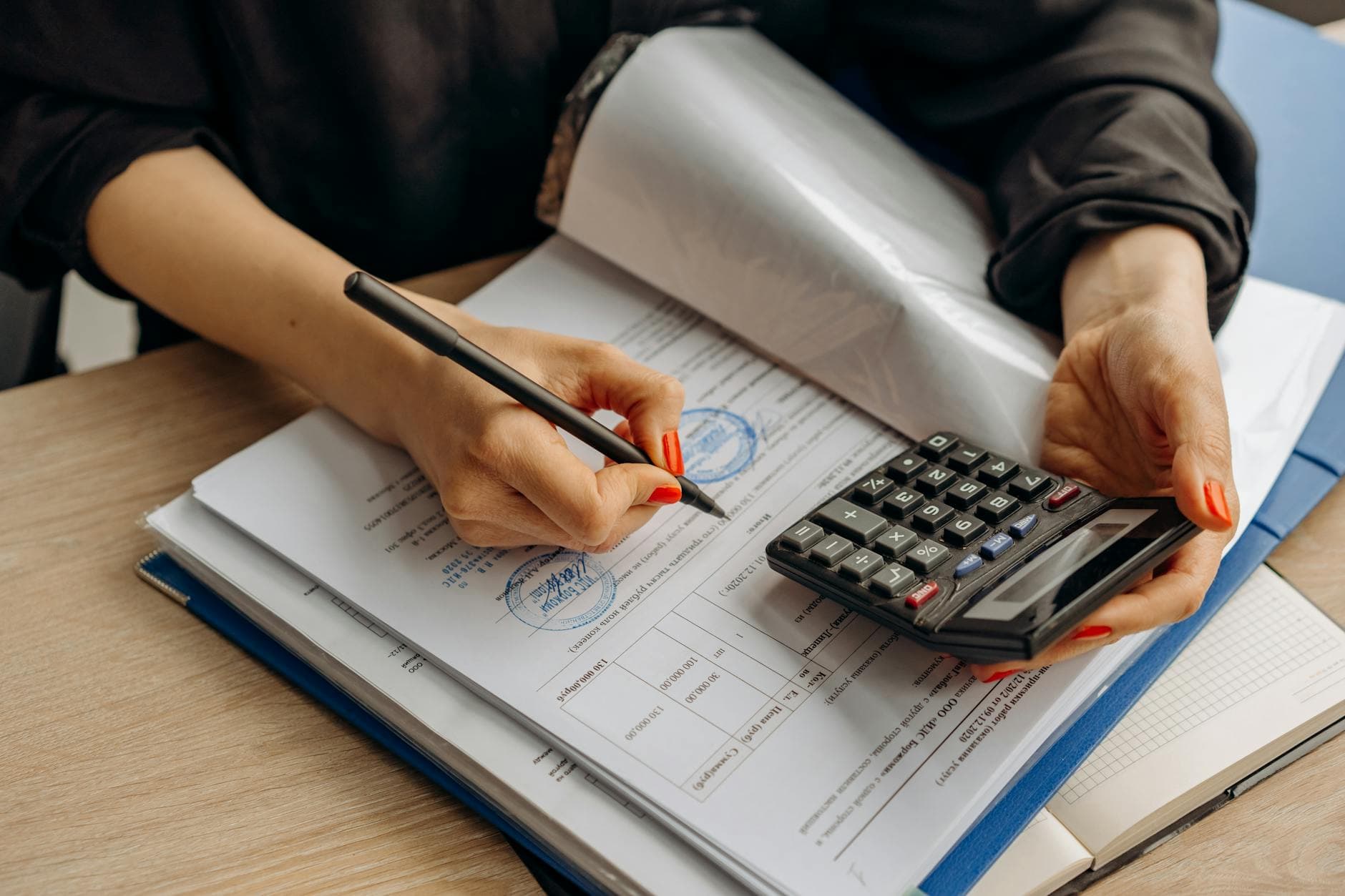 Compliance review — calculator and signed paperwork on a desk