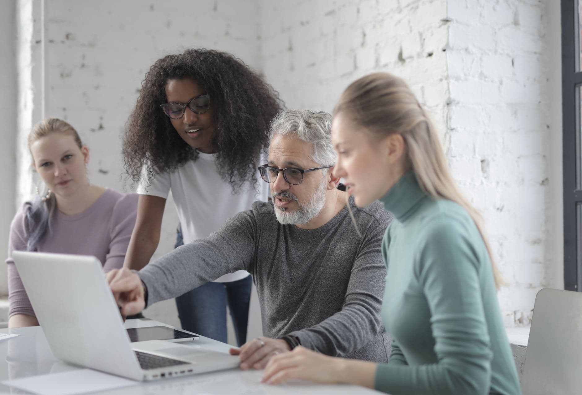 Team reviewing project on a laptop in a workspace