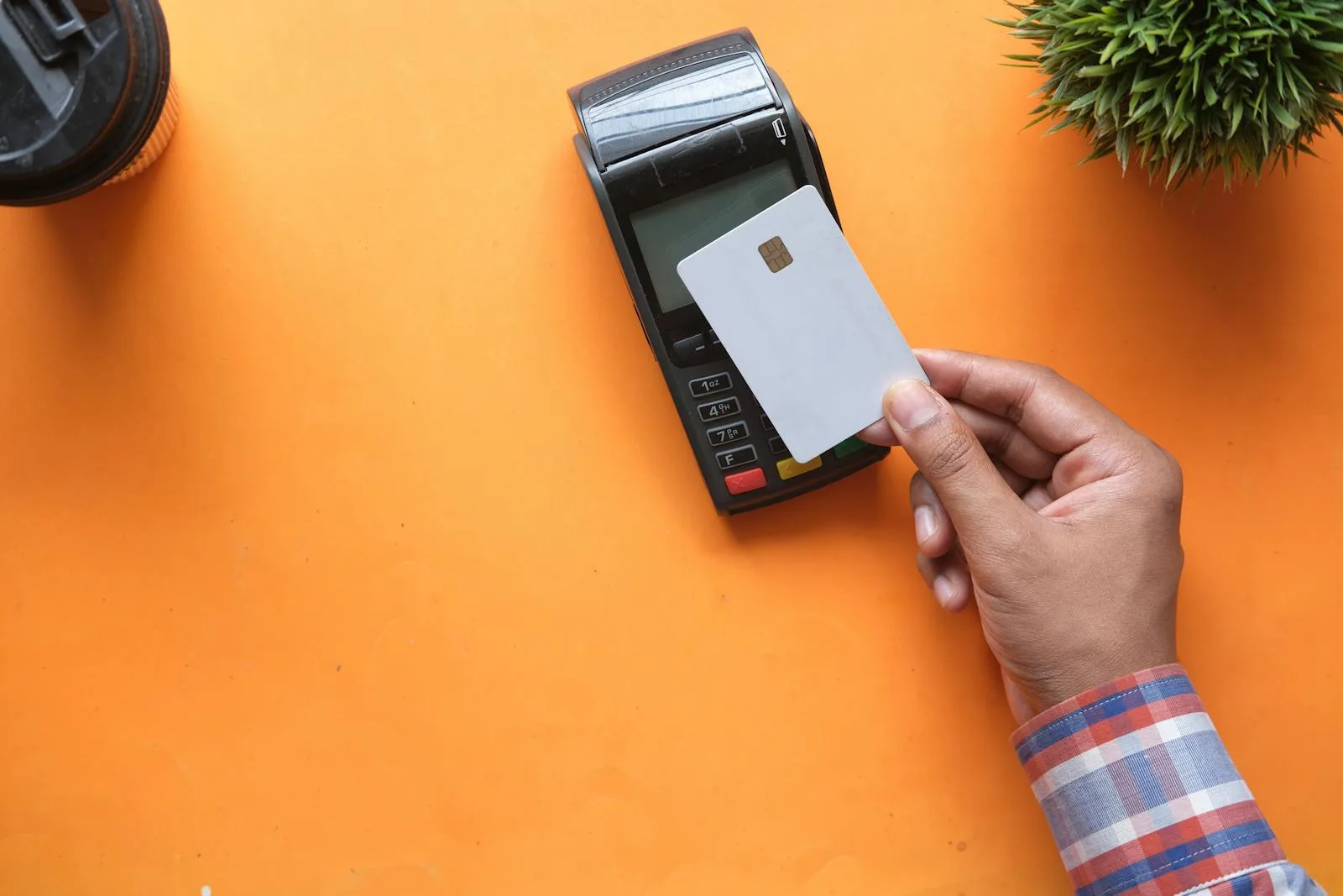 Close-up of a credit card being inserted into a chip-and-PIN payment terminal at checkout