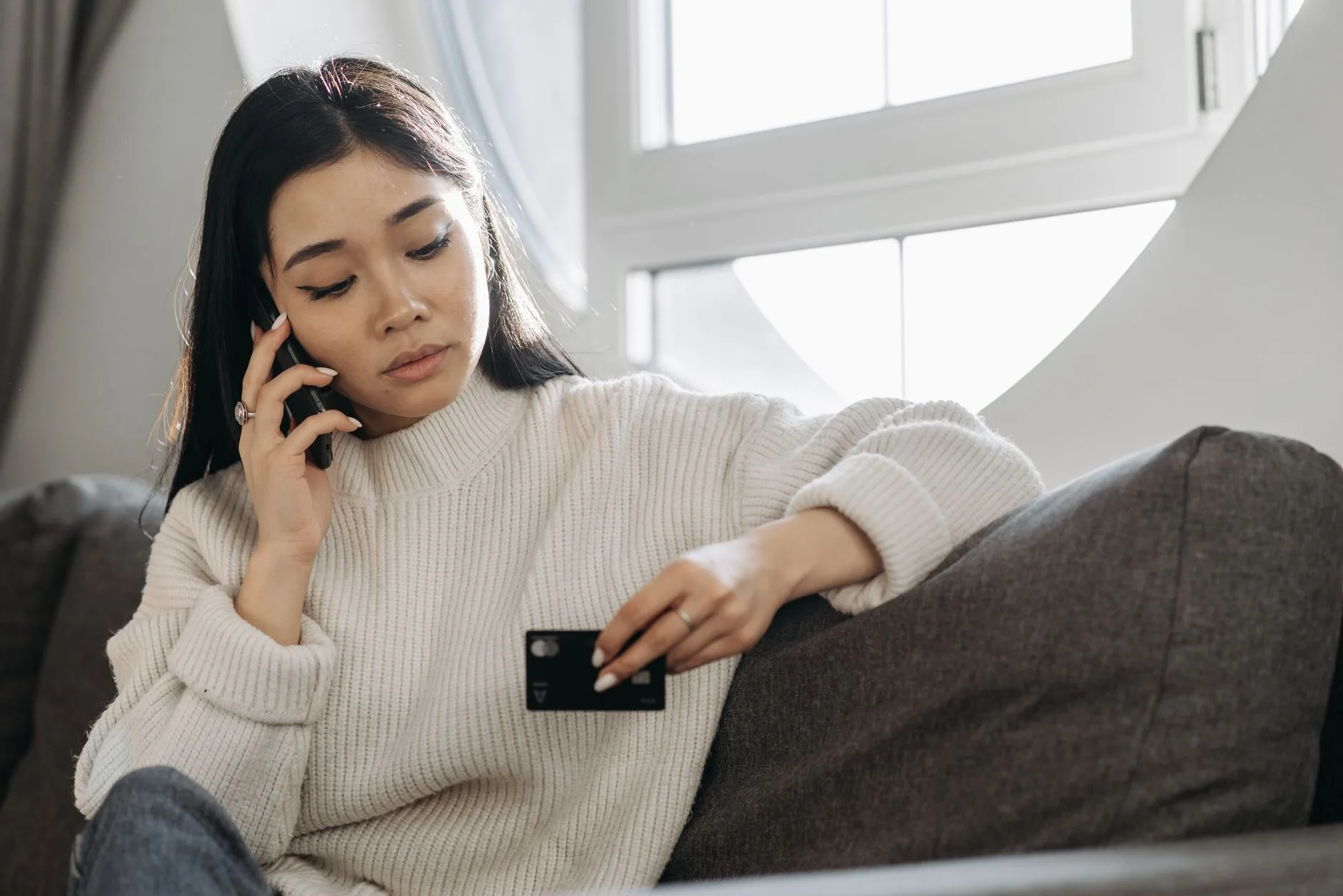 A customer holding a credit card during a telephone call and entering the digits on their handset keypad, the point at which Paytia captures card data without the agent or call recording detecting it